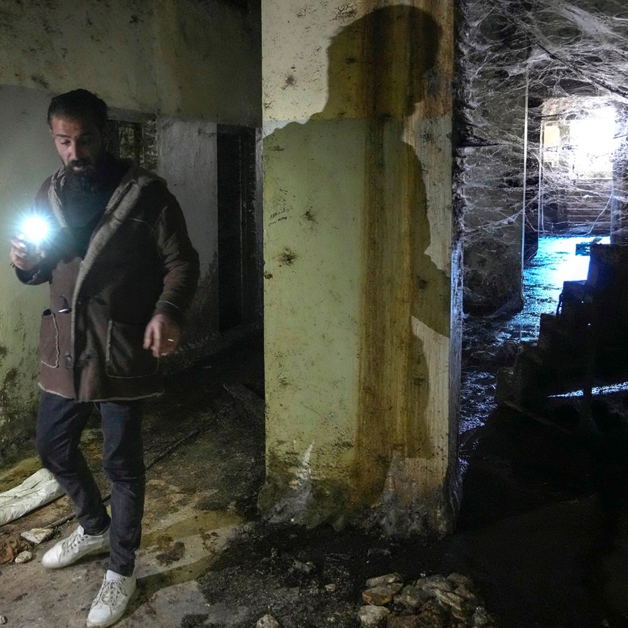 Zwei Männer inspizieren mit ihren Taschenlampen einen Korridor des berüchtigten Militärgefängnisses Saydnayah nördlich von Damaskus. © AP Foto: Hussein Malla