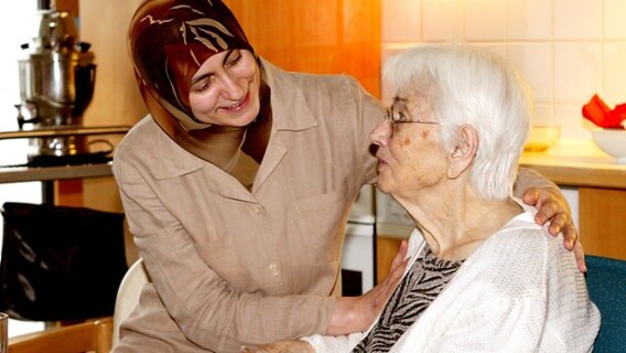 Muslimische Altenpflegerin umsorgt Seniorin. © picture alliance/Petra Steuer Foto: Petra Steuer