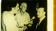 Stanisław Shlomo Szmajzner (rechts) und Gustav Wagner (mitte) 1978 auf der Polizeistation in São Paulo, Auszug aus historischem Filmmaterial aus dem Privatarchiv von Stanisław Szmajzner. © Archiv Stanislav Szmajzner 