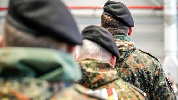Soldaten der Deutschen Bundeswehr mit Feldmützen und in Soldatenuniform stehen hintereinander. © Flashpic Foto: Jens Krick