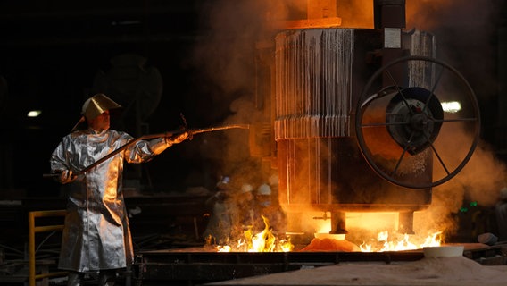 Stahlarbeiter mit Schutzkleidung vor einem Schmelzofen © picture alliance Foto: Christoph Hardt