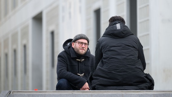 Ein Sozialarbeiter unterhält sich mit einem jungen Mann. © picture alliance/Marijan Murat Foto: Marija Murat