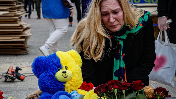 Anwohner legen am 14. April 2025 im Zentrum der ukrainischen Stadt Sumy Blumen an einer Gedenkstätte nieder, die zum Gedenken an die Opfer errichtet wurde, 14. April. © picture alliance / Anadolu Foto: Sofiia Bobok