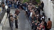 Mitglieder der Armee des ehemaligen Präsidenten Assad bzw. regierungsnahen Milizen registrieren sich im Rahmen eines "Identifizierungs- und Versöhnungsprozesses" bei der neu gebildeten syrischen Regierung. © AP/dpa Foto: Omar Sanadiki