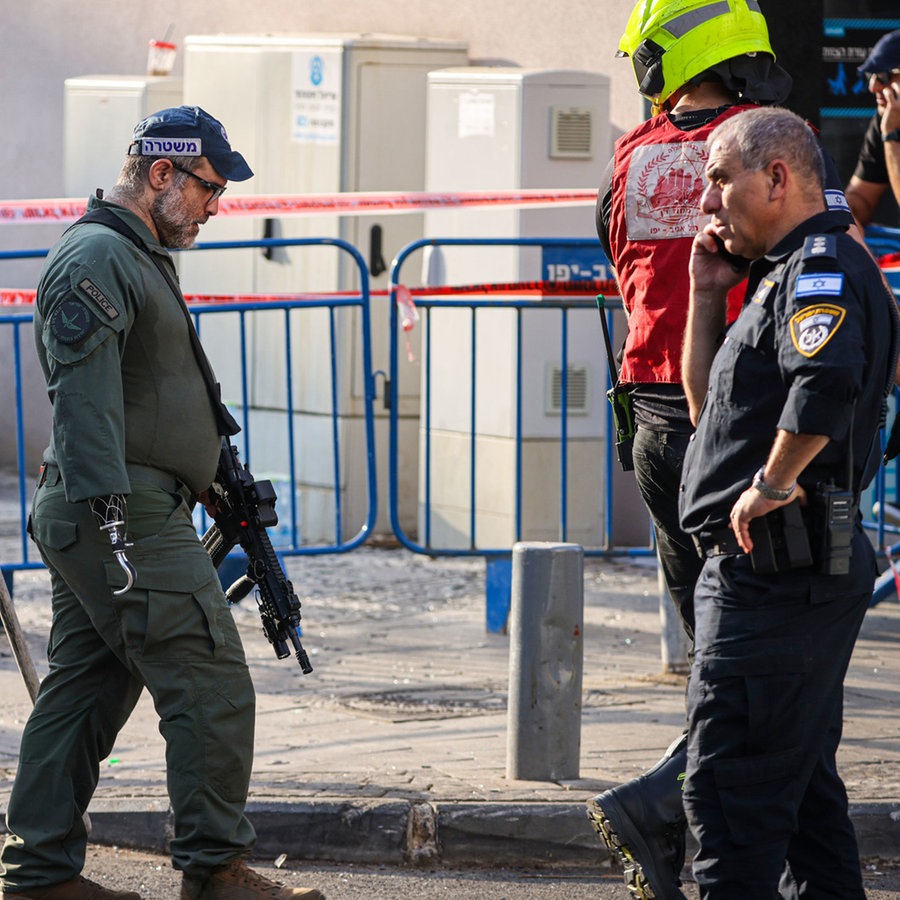 Israelische Polizisten durchsuchen den Ort einer Explosion in Tel Aviv. © dpa Foto: Ilia Yefimovich