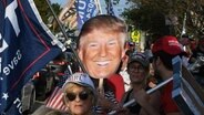 Anhänger von Donald Trump warten in West Palm Beach, Florida, auf den Ex-Präsidenten nach seiner Anklage in New York. © picture alliance Foto: Paul Hennessy
