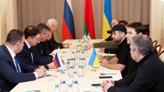 Vertreter der russischen und der ukrainischen Regierung sitzen an einem Tisch © picture alliance / ASSOCIATED PRESS | Sergei Kholodilin Foto:  Sergei Kholodilin
