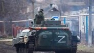 Ein russischer Panzer rollt durch das Dorf Bugas in der Ukraine. © picture alliance Foto: Taisiya Vorontsova