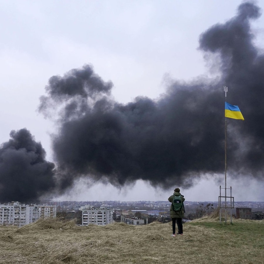 Schwarzer Rauch steigt nach Raketeneinschlägen auf Gebäude am Rande einer Stadt auf. © picture alliance/dpa/kyodo Foto: picture alliance/dpa/kyodo