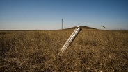 Eine russische Rakete steckt in einem Feld in Mykolajiw in der Ukraine. © picture alliance Foto: Vincenzo Circosta