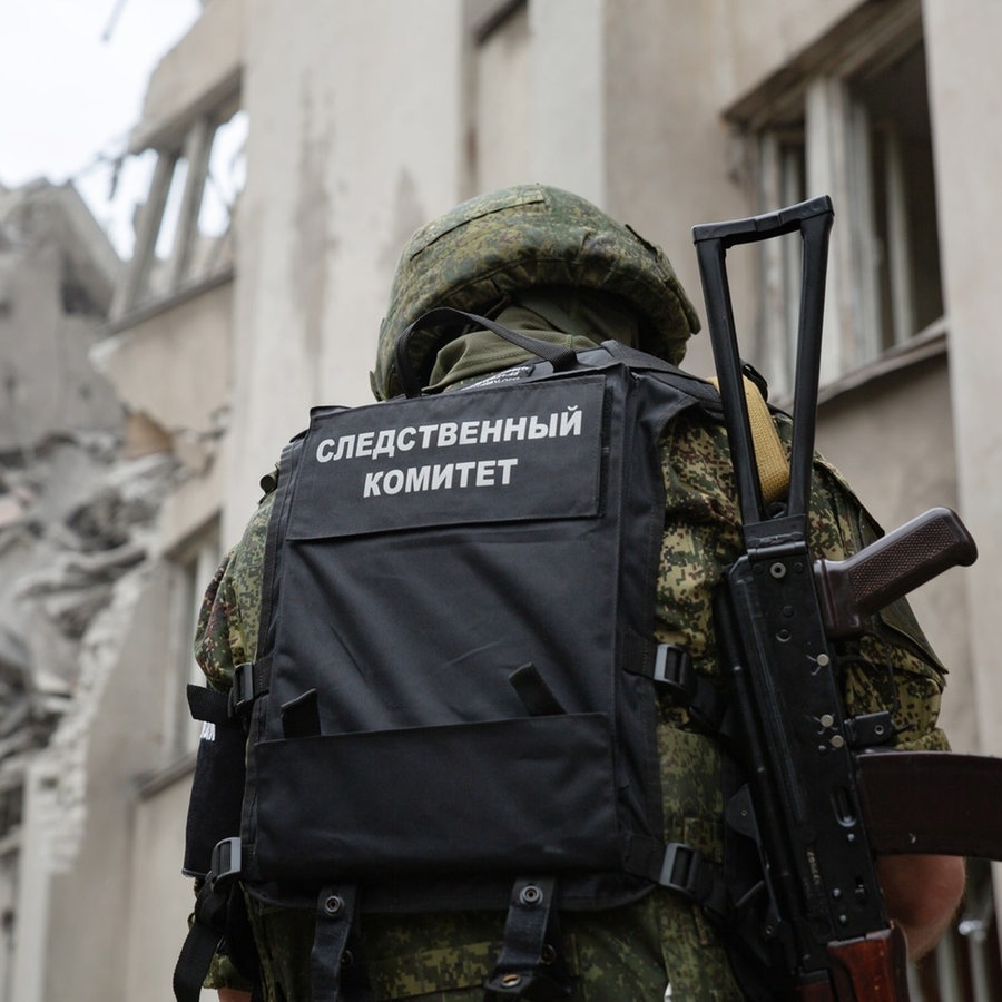 Ein russischer Soldat untersucht das zerstörte Donbass Hotel in der Region Lugansk. © picture alliance Foto: Alexander Reka