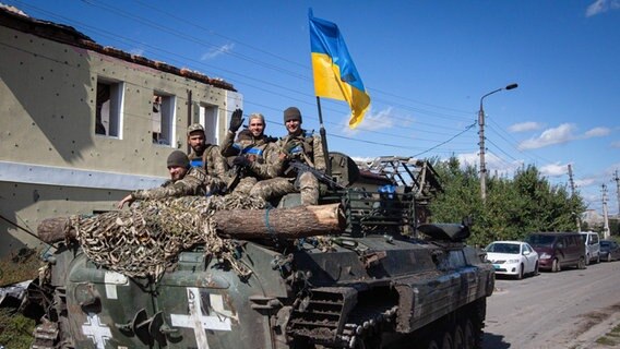 Ukrainische Soldaten fahren auf
einem gepanzerten Mannschaftswagen in der Stadt
Isjum in der Region Charkiw © picture alliance Foto: Oleksii Chumachenko