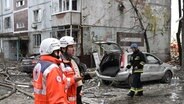 Rettungskräfte vor einem durch einen Angriff stark beschädigten Wohnhaus im ukrainischen Zaporizhzhia. © picture alliance / AA Foto: Muhammed Enes Yildirim