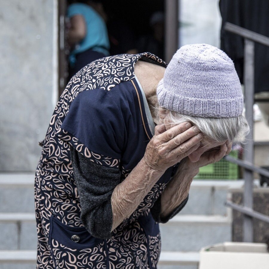 Ukraine: Eine alte, erschöpfte Frau hält ihren Kopf in den Händen © picture alliance / AA Foto: Narciso Contreras