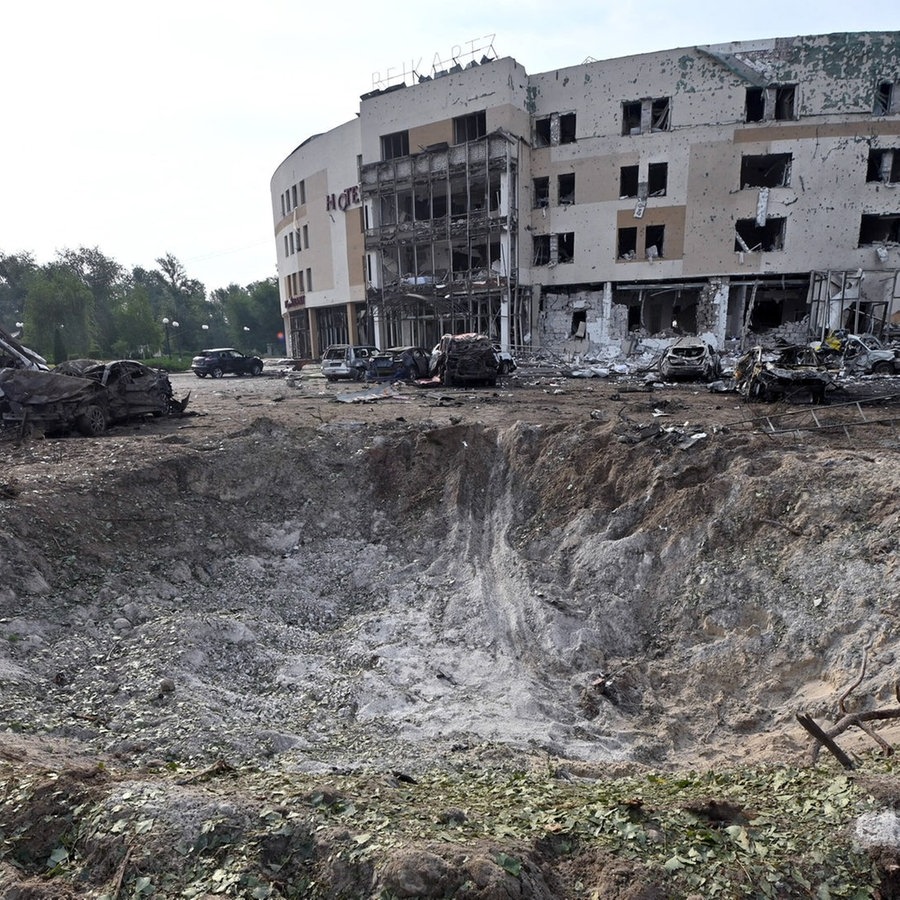 Vor einem Hotel in der ukrainischen Stadt Zaporizhzhia ist ein Krater zu sehen, der durch den Einschlag einer russischen Rakete verursachter Krater. © picture alliance / abaca | Koshelev Albert/Ukrinform/ABACA 