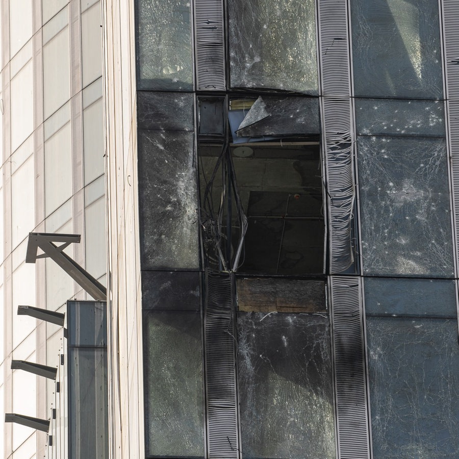 Eine Ermittlerin untersucht einen beschädigten Wolkenkratzer im Moskauer Geschäftsviertel Moskwa City nach einem gemeldeten Drohnenangriff. © picture alliance Foto: Bai Xueqi