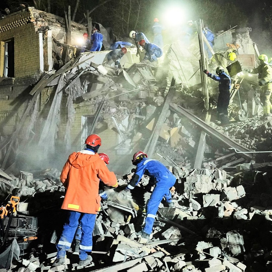 Ukrainische Helfer arbeiten in den Trümmern nach einem russischen Raketenangriff in Kiew, Ukraine, am frühen Donnerstag. Russland hat ukrainischen Angaben zufolge in der Nacht erneut mit Drohnen die ukrainische Hauptstadt Kiew angegriffen. © picture alliance/dpa/AP | Efrem Lukatsky Foto: Efrem Lukatsky