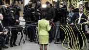 Sahra Wagenknecht steht vor Kameras nach einer Pressekonferenz zur Vorstellung des neuen Bündnis Sahra Wagenknecht - für Vernunft und Gerechtigkeit in der Bundespressekonferenz in Berlin am 23. Oktober 2023. © Imago Images Foto: Emmanuele Contini
