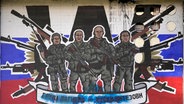 Ein beschmiertes Graffiti zeigt Kämpfer der Wagner Gruppe. © picture alliance Foto: Darko Vojinovic