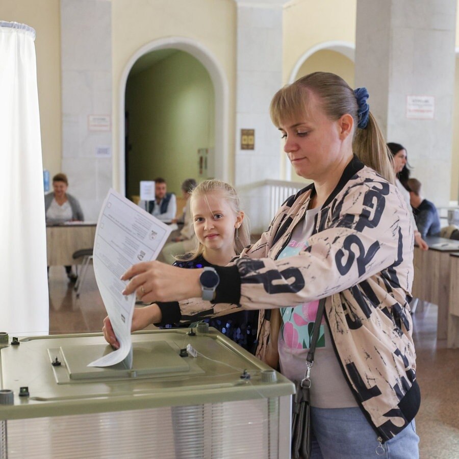 Eine Frau steckt einen Wahlzettel in eine Wahlurne. © picture alliance/dpa/TASS Foto: Erik Romanenko