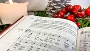 Liedtext und Noten des Liedes "Maria durch ein Dornwald ging" mit Weihnachtsdekoration © NDR Foto: Florian Breitmeier
