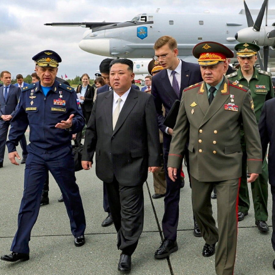 Nordkoreas Machthaber Kim Jong Un (Mitte) und der russische Verteidigungsminister Sergej Schoigu (rechts im Vordergrund) gehen auf dem Flughafen von Wladiwostok, um russische Kampfflugzeuge zu inspizieren. © Uncredited/Russian Defense Ministry Press Service/AP 