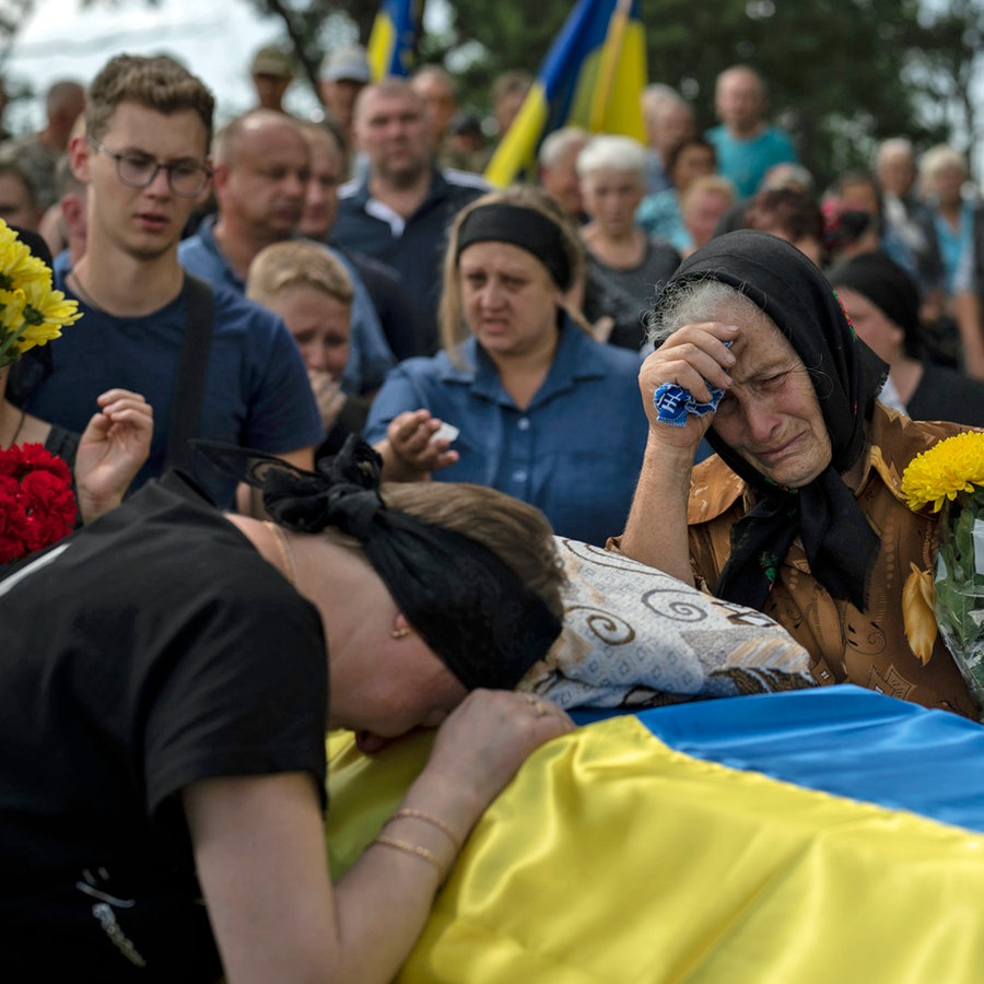 Oleksander Mykhailenkos Mutter Svitlana (links) und seine Großmutter Nadiia (rechts) trauern an seinem Sarg in Zhukin (Ukraine). © AP/dpa Foto: Bram Janssen