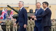 NATO-Generalsekretär Jens Stoltenberg (l.), der polnische Premierminister Donald Tusk und der britische Premierminister Rishi Sunak (r.) treffen gemeinsam in der Kaserne der Panzerbrigade in Warschau ein © Alastair Grant/AP POOL/AP 