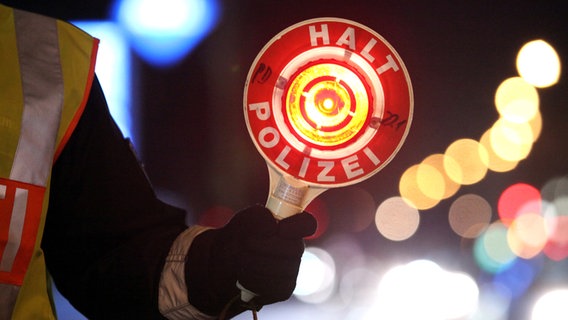 Ein Polizist hält eine Kelle mit der Aufschrift "Halt Polizei" in der Hand. © picture alliance / dpa Foto: Bodo Marks