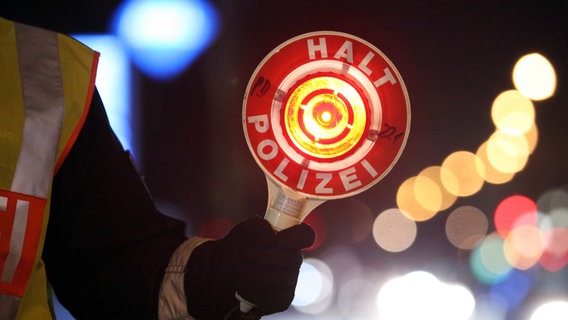 Ein Polizist hält eine Kelle mit der Aufschrift "Halt Polizei" in der Hand. © picture alliance / dpa Foto: Bodo Marks