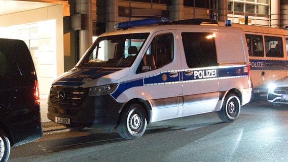 Polizeifahrzeuge stehen in Berlin vor einem Haus. © picture alliance/dpa | Paul Zinken 