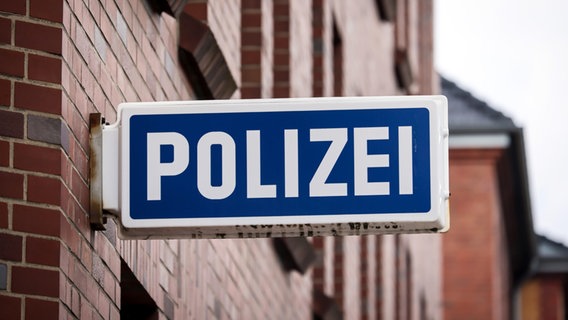 Ein blaues Polizeischild ist an einer Backsteinfassade angebracht. © picture alliance Foto: Rupert Oberhäuser
