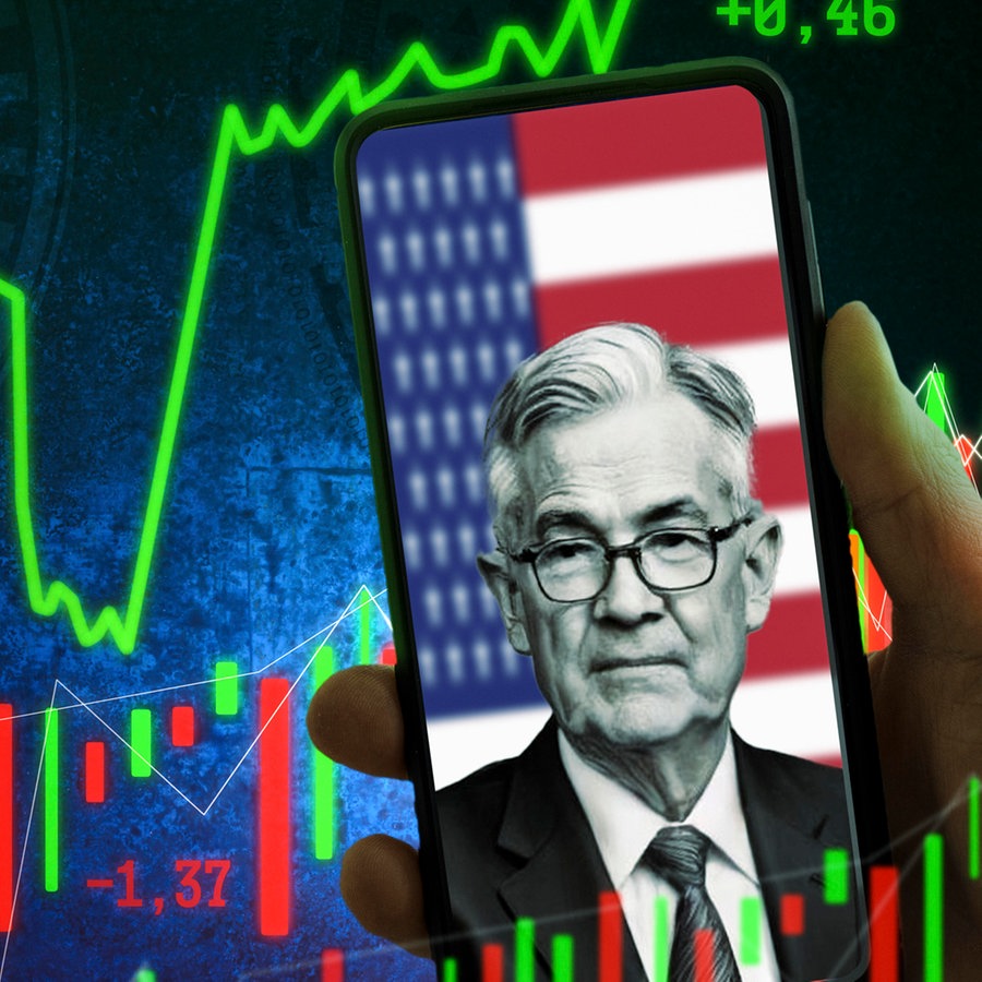 Jerome Powell, Chef der Federal Reserve System (FED), bzw. US-Notenbank auf einem Handy vor einer US-Flagge. Im Hintergrund werden Börsencharts angezeigt - Fotomontage
Aufnahmedatum Handy vor einer USA-Flagge. Symbolik Reden & Entscheidungen durch den Notenbank-Chef und Auswirkungen auf US-Dollar und Aktien. Fotomontage © picture alliance / CHROMORANGE Foto: Michael Bihlmayer