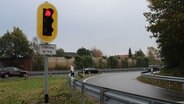 Eine rotleuchtende Ampel steht vor der Auffahrt zur Autobahn A23. © NDR Foto: Janine Artist