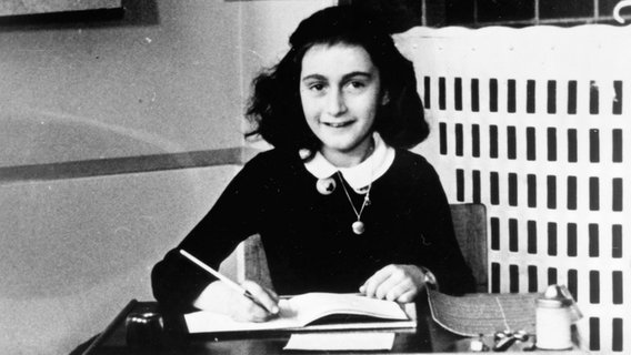 Ein Porträtbild in schwarz-weiß zeigt Anne Frank beim Schreiben. © IFTN UnitedArchives 06039 