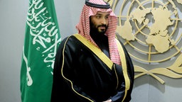 Der saudi-arabische Kronprinz Mohammed bin Salman vor einer Flagge seines Landes und dem Zeichen der UN (2018). © dpa picture alliance Foto: Dennis Van Tine