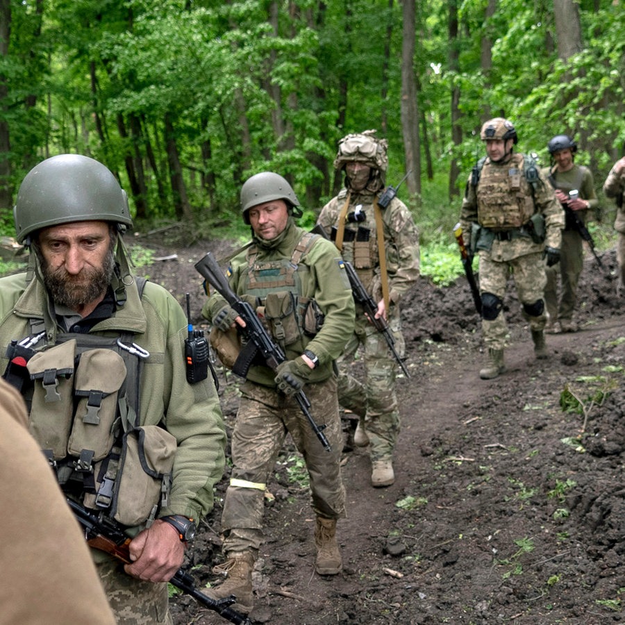 Ukrainische Soldaten gehen in der Nähe eines kürzlich zurückeroberten Dorfes nördlich von Charkiw in der Ostukraine durch den Wald. © AP/dpa Foto: Mstyslav Chernov