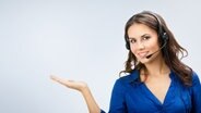 Frau mit einem Headset streckt die rechte Hand aus. © vgstudio/fotolia Foto: vgstudio