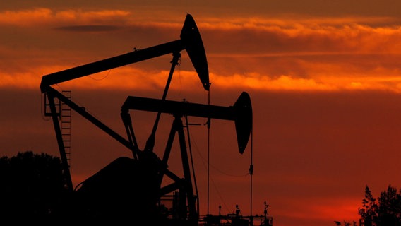 Ölpumpen stehen im Sonnenuntergang auf einem Ölfeld © picture alliance / dpa Foto: epa Paul Buck
