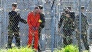 Amerikanische Militärpolizisten führen im Militärgefängnis Guantánamo auf Kuba einen Gefangenen ab. © dpa Foto: Roberto Schmidt