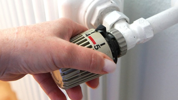 Eine Hand dreht am Thermostat eines Heizkörpers. © Eibner-Pressefoto | Fleig Foto: Fleig / Eibner-Pressefoto