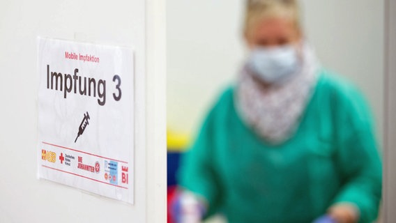 Ein Schild "Impfung 3" ist an der Tür zu einem Impfraum zu sehen. © dpa Foto: Friso Gentsch