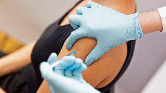 Eine Frau lässt sich bei gegen Covid-19 in den Oberarm impfen. © dpa Foto: Moritz Frankenberg