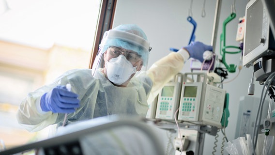 Ein Intensivpfleger arbeitet auf einer Intensivstation eines Krankenhauses an einer an Covid-19 erkrankten Patientin. © dpa Foto: Kay Nietfeld