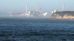 Japan, Namie: Das Kernkraftwerk Fukushima Daiichi ist vom nahegelegenen Fischereihafen Ukedo in der Stadt Namie im Nordosten Japans zu sehen. © AP Foto: Eugene Hoshiko