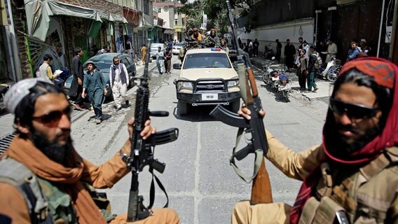 Entlang einer Straße in Kabul patrouillieren Taliban-Kämpfer. © Rahmat Gul/AP/dpa Foto: Rahmat Gul/AP/dpa