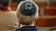 Ein Mann mit einer Kippa auf dem Kopf sitzt in der Synagoge in Dresden. © dpa bildfunk Foto: Sebastian Kahnert