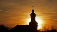 Umrisse einer Kirche bei Sonnenuntergang. © Imago/Blickwinkel 