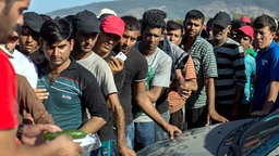 Flüchtlinge warten auf der griechischen Insel Kos an der Essensausgabe. © dpa bildfunk Foto: Santi Palacios