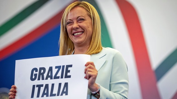 Die Vorsitzende der rechtsradikalen Partei Fratelli d'Italia (Brüder Italiens), Giorgia Meloni, hält ein Schild mit der Aufschrift "Grazie Italia" ("Danke Italien") während einer Pressekonferenz in der Wahlkampfzentrale ihrer Partei. © dpa Foto: Oliver Weiken